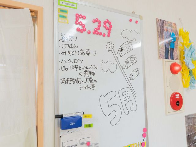 掲示物のホワイトボード 掲示物 ホワイトボードには、日付や献立が書かれており、イベント情報や季節の装飾が施されています。
