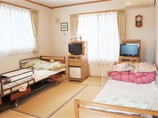 畳敷きの部屋にベッドが二つ並び、テレビもそれぞれについている。大きな窓にはカーテンもある。