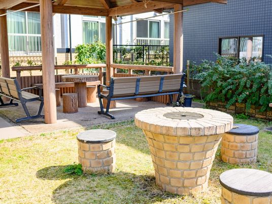芝生の庭にあずま屋や露天のテーブルセットが置かれている。植込みには庭木が植えられており、緑を楽しむことができる。