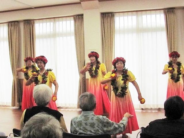 多目的室でのフラダンス イベント 笑顔明るいフラダンスの披露に、観る方々も和やかな表情です。こうした活動は、日々の生活に彩りと潤いを提供します。