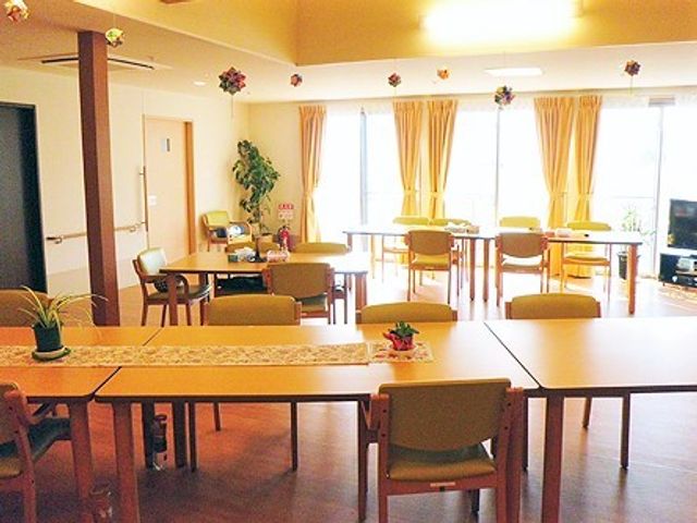 明るく広々とした共有空間 食堂 ゆったりとした食堂では、テーブルごとに花が飾られ、くつろぎながら食事を楽しむことができます。壁掛けのテレビもあり、コミュニケーションの場としても活用されています。