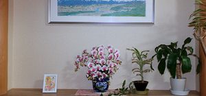 花と絵画が飾られた棚