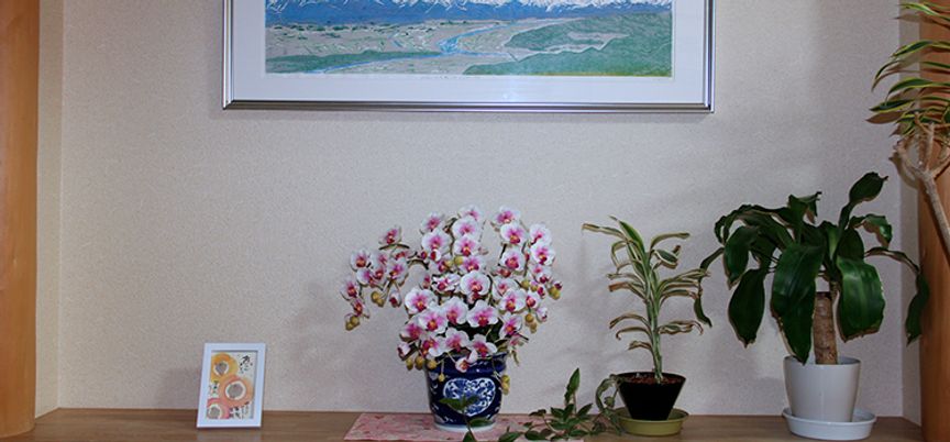 花と絵画が飾られた棚