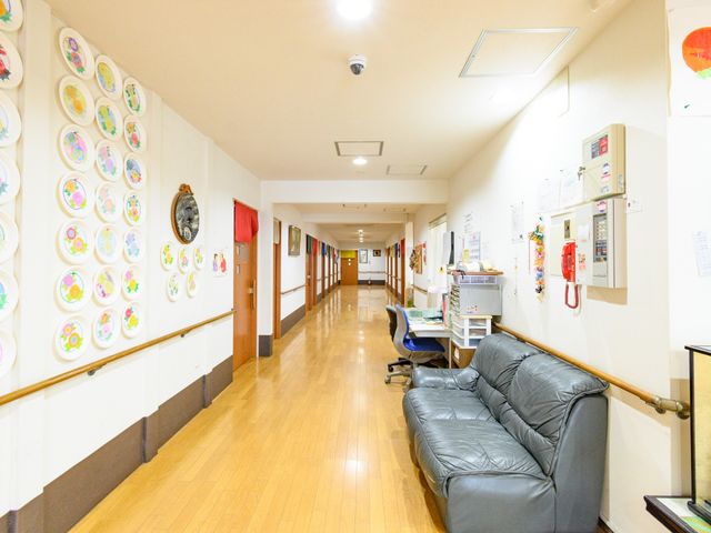 廊下にある椅子と装飾 廊下 温かみのある装飾が施された廊下です。レザーのソファが設置されており、休憩にも適しています。