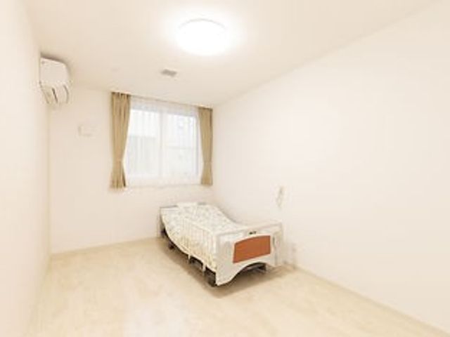 窓際にベッドがある居室 居室 窓から自然光が差し込む明るい居室です。清潔感があり、落ち着いた雰囲気を感じられます。