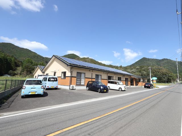 山々に囲まれた建物外観 外観 自然豊かな環境に位置する明るい施設です。心地よい空気が流れ、新しい職場として最適な場所を提供します。
