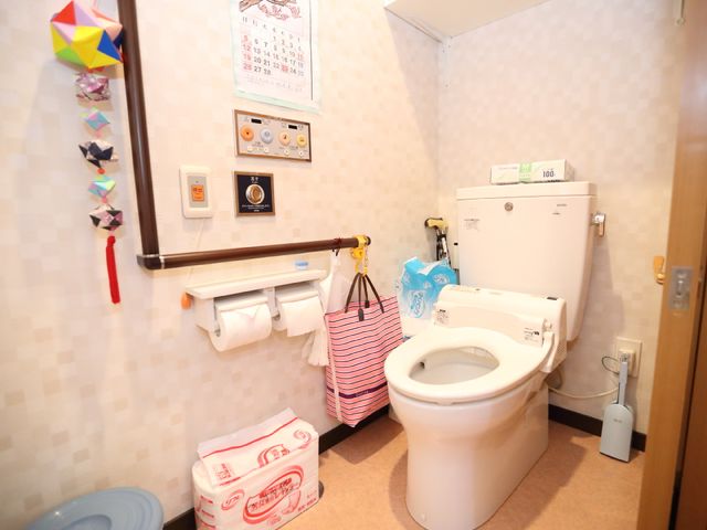 手すり付トイレ空間 トイレ 手すりや緊急呼び出しボタンが設置された清潔なトイレです。利用者の安全と快適を考えた設計になっております。