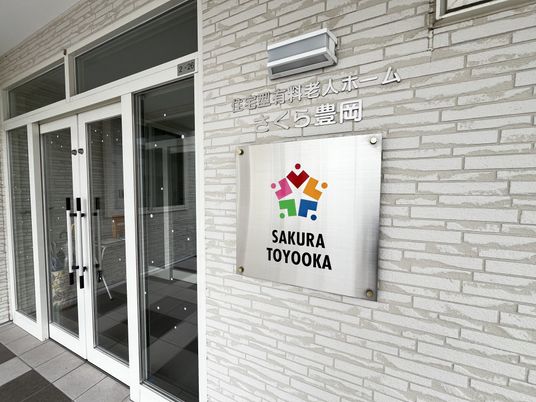 施設の入口看板とガラス扉の外観  