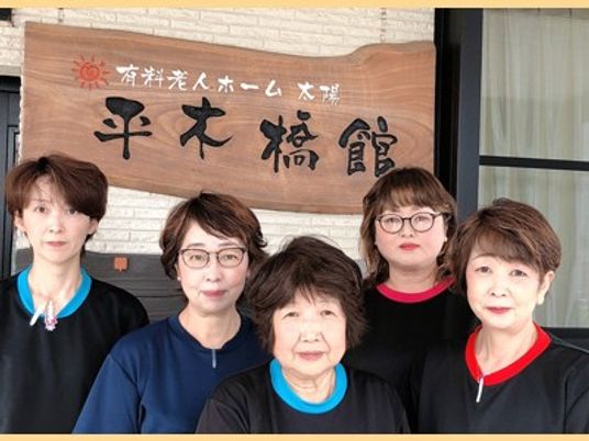 職員が並ぶ施設前