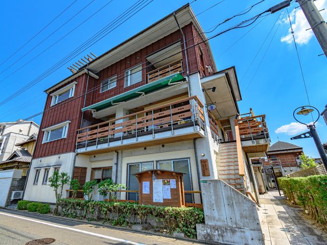 多階層の建物外観 外観 街中に佇むこの建物は、木の温もりを感じる外壁とバルコニーが特徴です。周囲の環境と調和しながら、機能性と落ち着きを兼ね備えています。