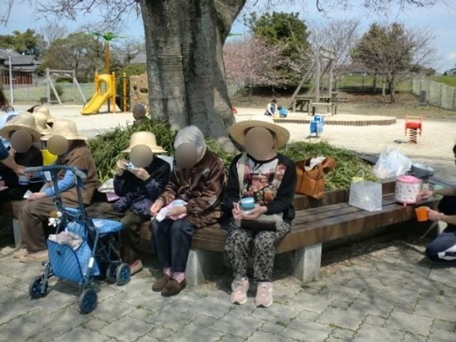 心地よい中庭で過ごす人々 お花見 澄んだ空気の中で、ゆったりとした時を過ごす方々の様子です。公園のような開放感のある場で、皆さまがリラックスしています。