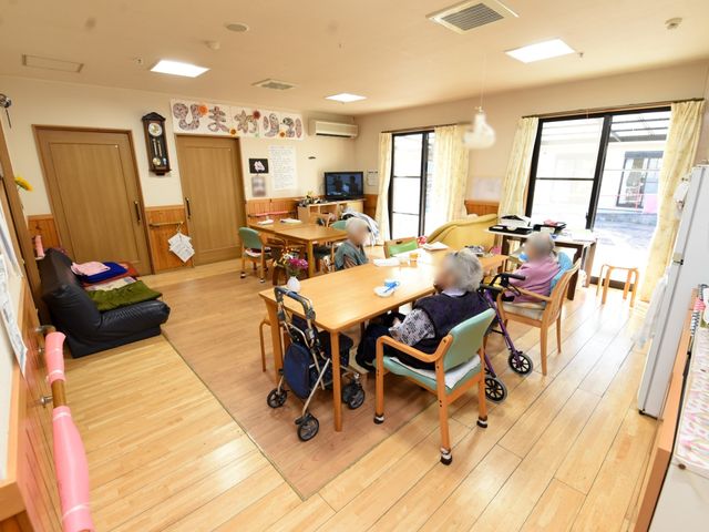 明るい共有リビング空間 共有スペース 居心地の良いリビングで、皆様が穏やかな時間を過ごしていらっしゃいます。ゆったりとしたソファでのくつろぎや、交流が生まれる空間となっています。