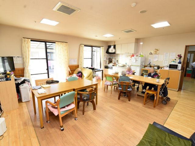共有スペースの様子 共有スペース 広々としたダイニングで利用者が会話を楽しみながら食事をされています。キッチン周りも清潔に保たれ、明るく家庭的な雰囲気が漂います。