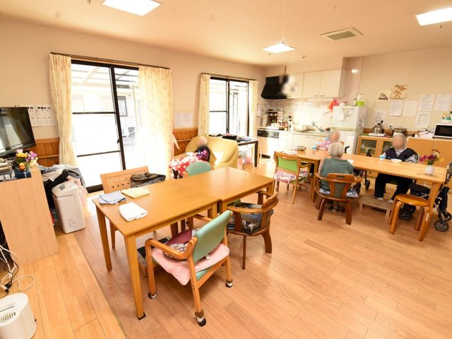 共有スペースの日常風景 共有スペース 広々としたダイニングルームで、ご入居者が心地よい時間を過ごしています。キッチンには必要な設備が整い、調理のサポートも行える環境です。