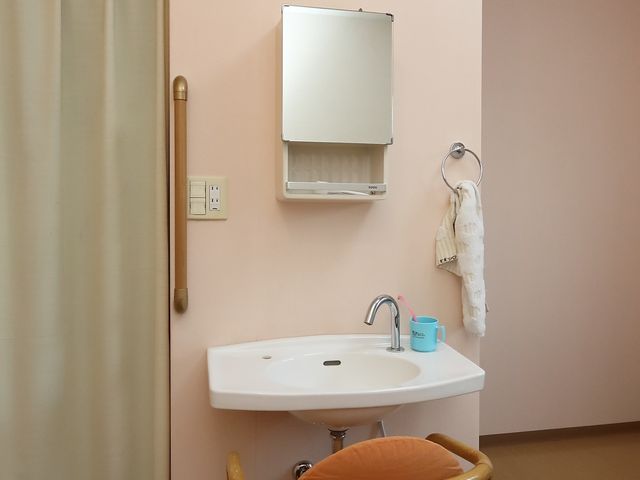洗面所の洗面台と椅子 洗面台 ゆったりとした洗面台の前には椅子が置かれ、利用者の快適な生活支援を考えた設計がされています。
