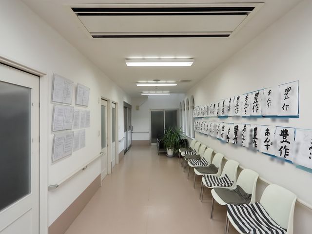 廊下の風景 通路 清潔で広々とした通路が確保されており、壁には掲示物が整然と掲げられ、待合いスペースも設けられています。