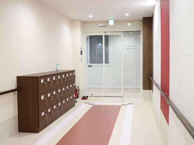 清潔感のある廊下の風景 エントランス 清潔で明るい廊下は、心地よい移動空間を提供しています。壁面には手すりが備えられ、安全に配慮されています。