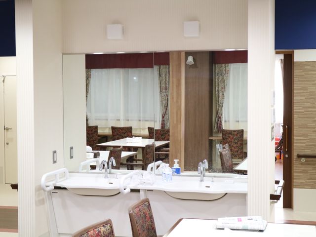 清潔なダイニングルーム風景 洗面台 手入れが行き届いたダイニングスペースです。食事の準備ができる大型シンクも設置され、機能的な空間となっています。
