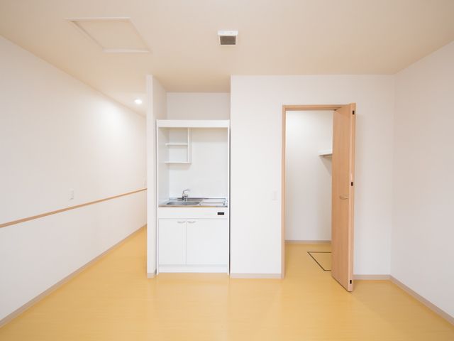 清潔な居室空間 居室 このシンプルなデザインの居室は、居心地の良さを大切にしている空間です。手元には清掃が行き届いたキッチンも完備しています。