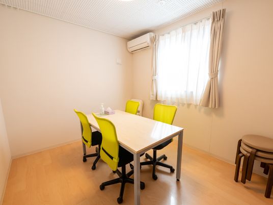 黄色い椅子とテーブルと椅子がおかれている相談室