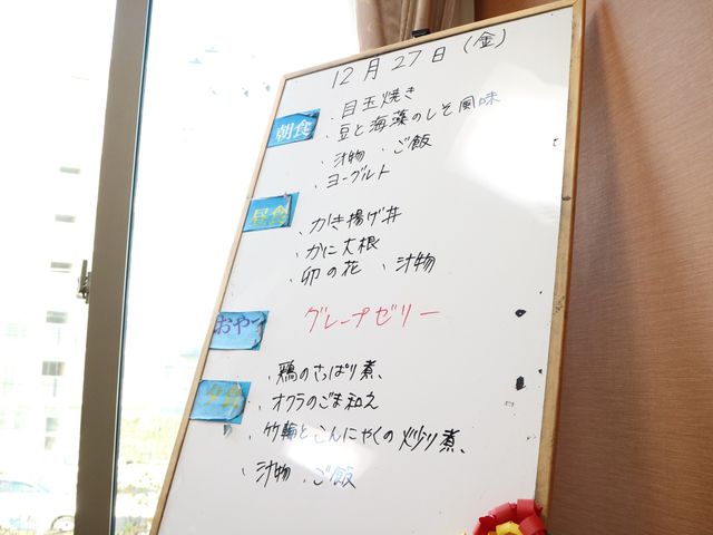 掲示物のある空間 メニュープレート 掲示板には日々のスケジュールが明記され、職員も利用者も一日の流れを共有できます。機能的なコミュニケーションが促進される工夫が見られます。