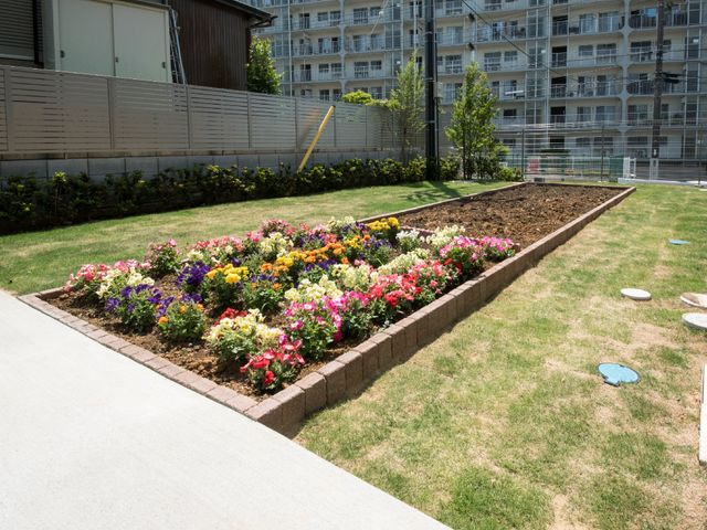 花壇付きのきれいな中庭 花壇 色とりどりの花々が植えられた明るい中庭です。屋外での憩いのひと時を提供し、心地よい日々を過ごせる空間が広がっています。