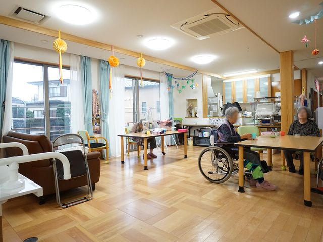 共有スペースの活動風景 共有スペース 暖かな雰囲気のダイニングルームで、利用者が穏やかな時間を過ごしています。開放的で明るい空間があなたの職場になります。