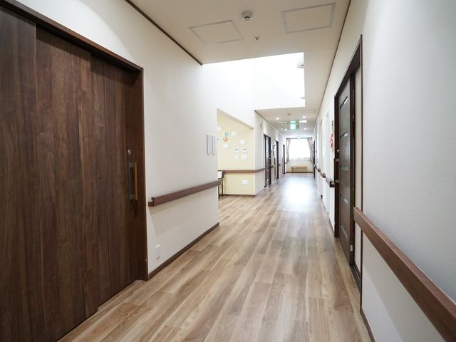 木目調の清潔な廊下 廊下 木の温もりを感じさせる廊下は、明るく開放的な雰囲気があります。ゆったりとした空間で安全に歩行できる設計です。