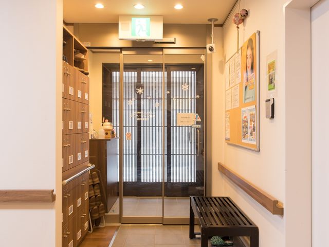 玄関付近の明るい空間 玄関 温かみのあるエントランスは、清潔感があり、来訪者を安心して迎え入れます。掲示物も整然と並び、情報共有スペースとして機能しています。