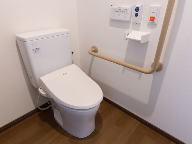 バリアフリートイレ設備 トイレ 安全に配慮した設計のトイレです。手すりが設置され、日々の生活をサポートします。