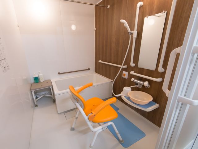 バリアフリー浴室 浴室 安全な介助のための手すりと座席を完備した快適な浴室です。利用者のケアをサポートする設備が整っています。