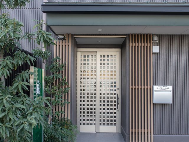 エントランスの正面 玄関 落ち着いた色調のエントランスは、訪れる方を優しく迎え入れます。私たちと一緒に温かな空間をお作りしませんか。