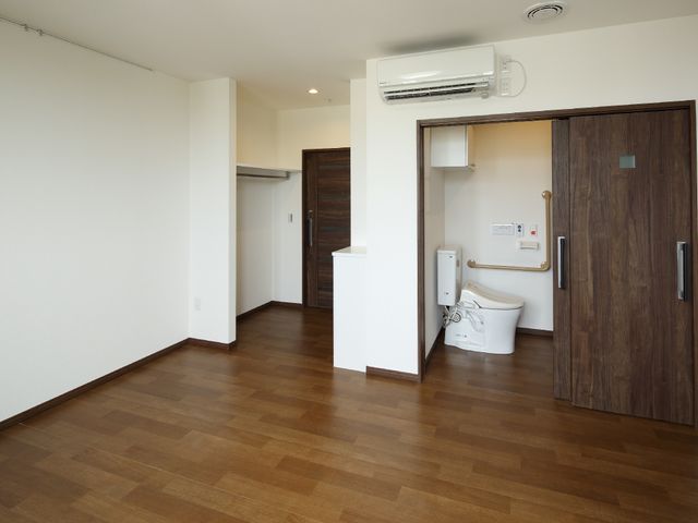 居室のトイレ付き空間 居室 広々とした清潔な居室が印象的です。手すり付きのトイレも完備しており、利用者の安全と快適さを考慮しています。