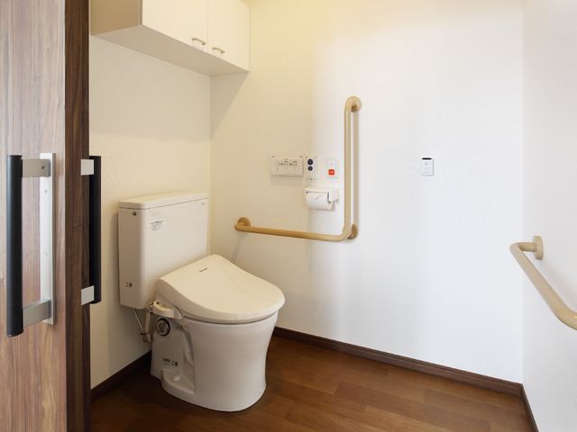バリアフリートイレ トイレ 手すり付きの清潔なトイレスペースです。安全を考慮した設計で、すべての方が快適にご利用いただける環境を整えています。