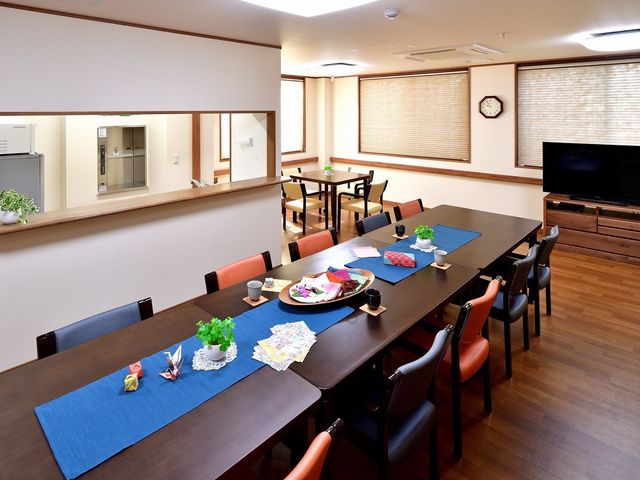 明るい食堂の様子 食堂 ゆったりとした食堂で、仲間との食事や会話を楽しめる空間が整っています。手作りの装飾品が温かい雰囲気を演出しており、リラックスした時間を過ごせそうです。