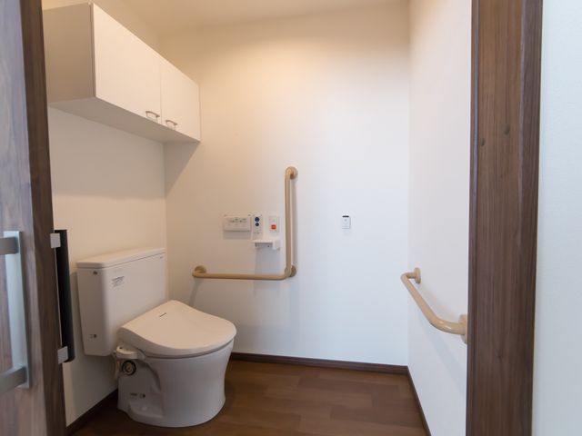 バリアフリー設計のトイレ トイレ 安全で快適なトイレは、手すりが完備されており、日々の生活をサポートします。清潔感のある空間で、安心してお使いいただけます。