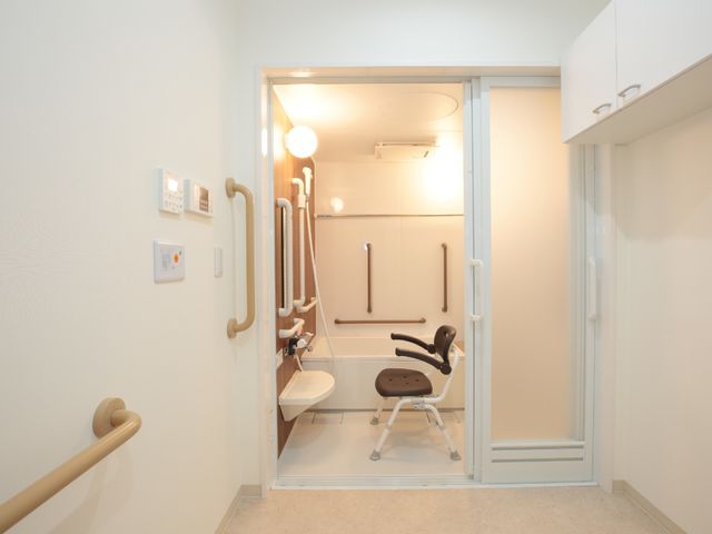 バリアフリーのトイレ 浴室 手すり付きのトイレ椅子が設置された清潔感あふれるトイレ空間です。安全に配慮された設計で、どなたでも安心してご利用いただけます。