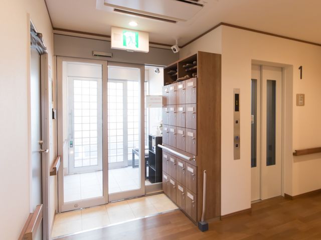 エントランスの明るい通路 玄関 広々としたエントランスは、訪れる方々を温かく迎え入れます。明るく落ち着いた雰囲気の中で、新たな職場を見つけませんか？