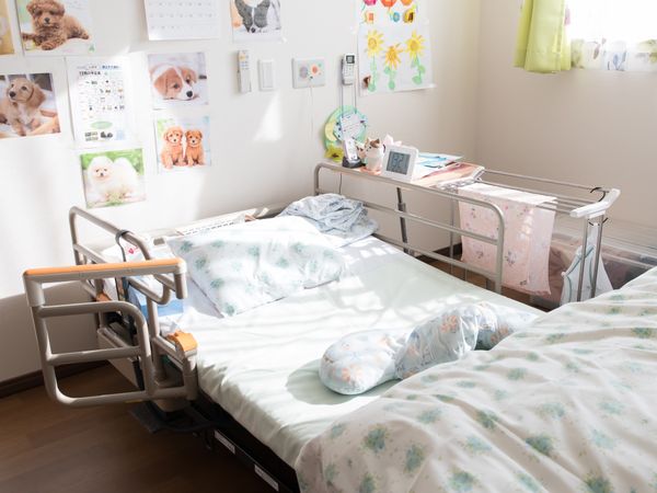 明るい居室のベッドと壁