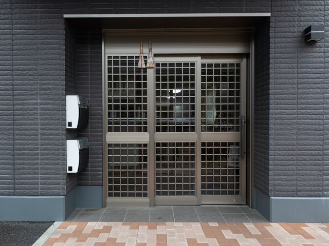 モダンな建物のエントランス エントランス 落ち着いた色合いのエントランスは、訪れる人を優しく迎え入れます。清潔感があり、安心して働ける環境が整っています。