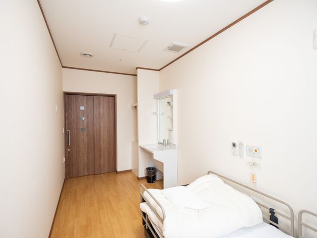清潔感のある居室 部屋 ゆとりある広さの個室で、明るい色合いが心地よい空間を演出しています。洗面台も完備され、快適な個人の時間を過ごせる設計となっております。