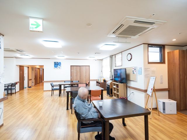 共用スペースで一人座る方居室 共用スペース 広々とした食堂は、ゆったりとした時間が流れる居心地の良い空間です。一人で過ごされる方も、心地よい憩いの場としてお使いいただけます。