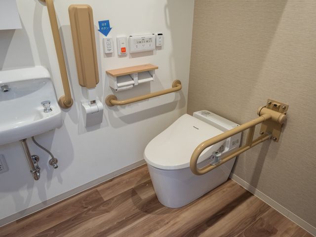 バリアフリートイレ設備 トイレ 手すり付きのトイレは安全に配慮されており、安心してご利用いただけます。清潔で機能的な空間設計が就業環境の良さを伺わせます。