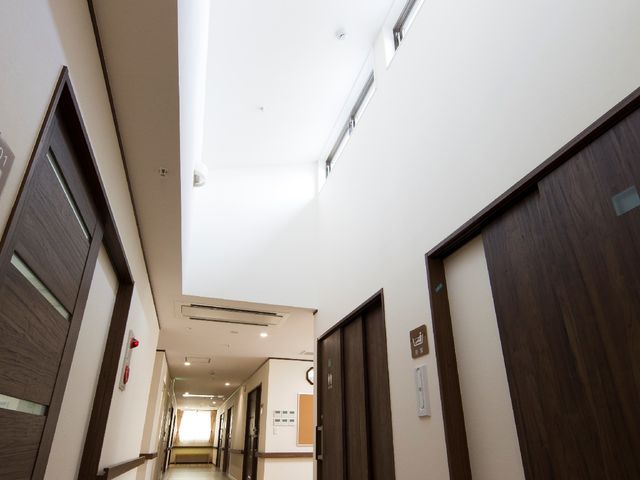 明るく広々とした廊下 廊下 清潔感があり、柔らかな光が差し込む廊下は、移動も快適であり、日々の生活に安心を提供します。