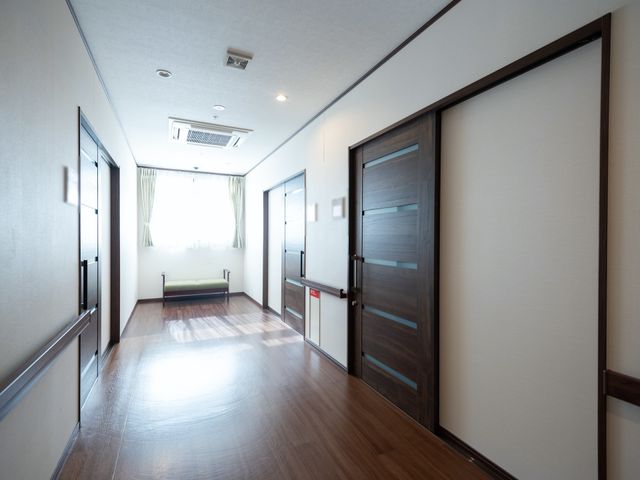 明るい清潔な廊下 廊下 ゆったりとした通路が広がる快適な空間です。自然光が差し込む窓辺にはベンチがあり、一息つくことができます。