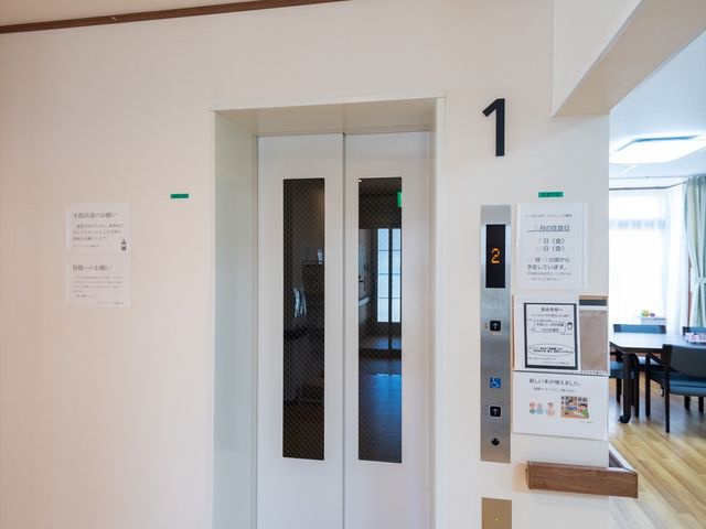 エレベーターと案内表示 エレベーター ゆとりのある設計がされたエレベーター前です。周囲には各種案内や日程が掲示され、情報が手に取りやすい環境が整っています。