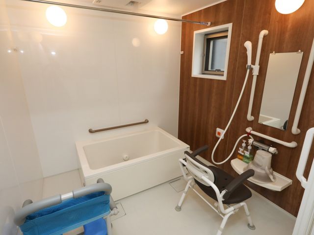 バリアフリーの清潔な浴室 浴室 安全手すりが整った清潔感のあるこの浴室は、使用者の方々の快適さを考えた安心の設計です。車椅子対応の浴槽とシャワーがありますので、皆様にご利用いただけます。