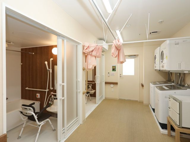 手すり付き浴室付属設備 浴室 広々とした浴室には安全に配慮された手すりが設置されており、洗濯機も完備されています。快適さと利便性を兼ね備えた環境で、快適な日々を支援します。