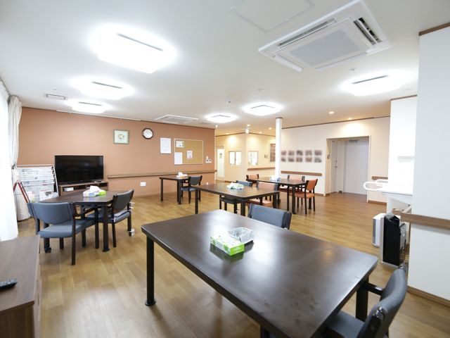 共用のリビングスペース 食堂 ゆとりある共用の食堂では、ご入居者様が食事や交流を楽しまれています。テレビが設置されており、リラックスした雰囲気の中で過ごせますよ。