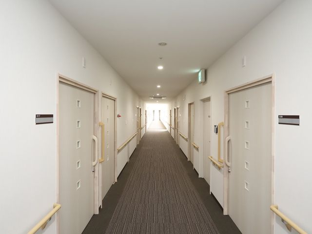清潔な廊下の様子 廊下 手すりが設置された明るい通路です。安全に配慮しつつ、居室へのアクセスが容易になっています。